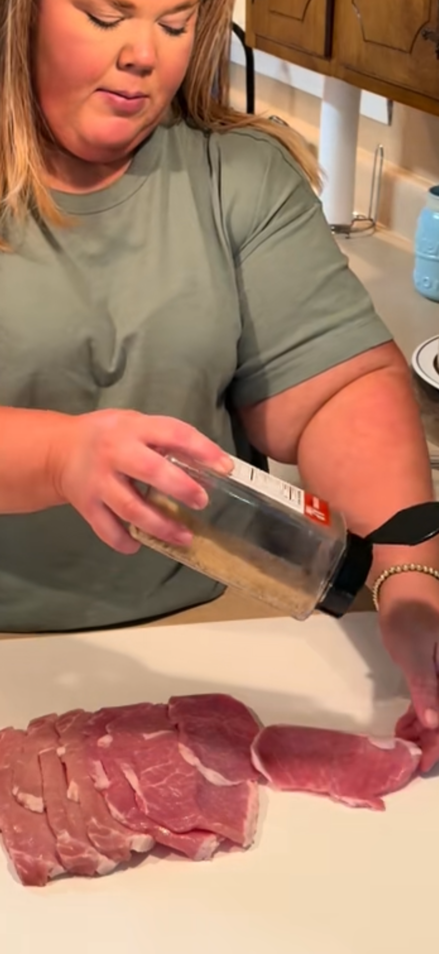 A person holding a bottle of food.