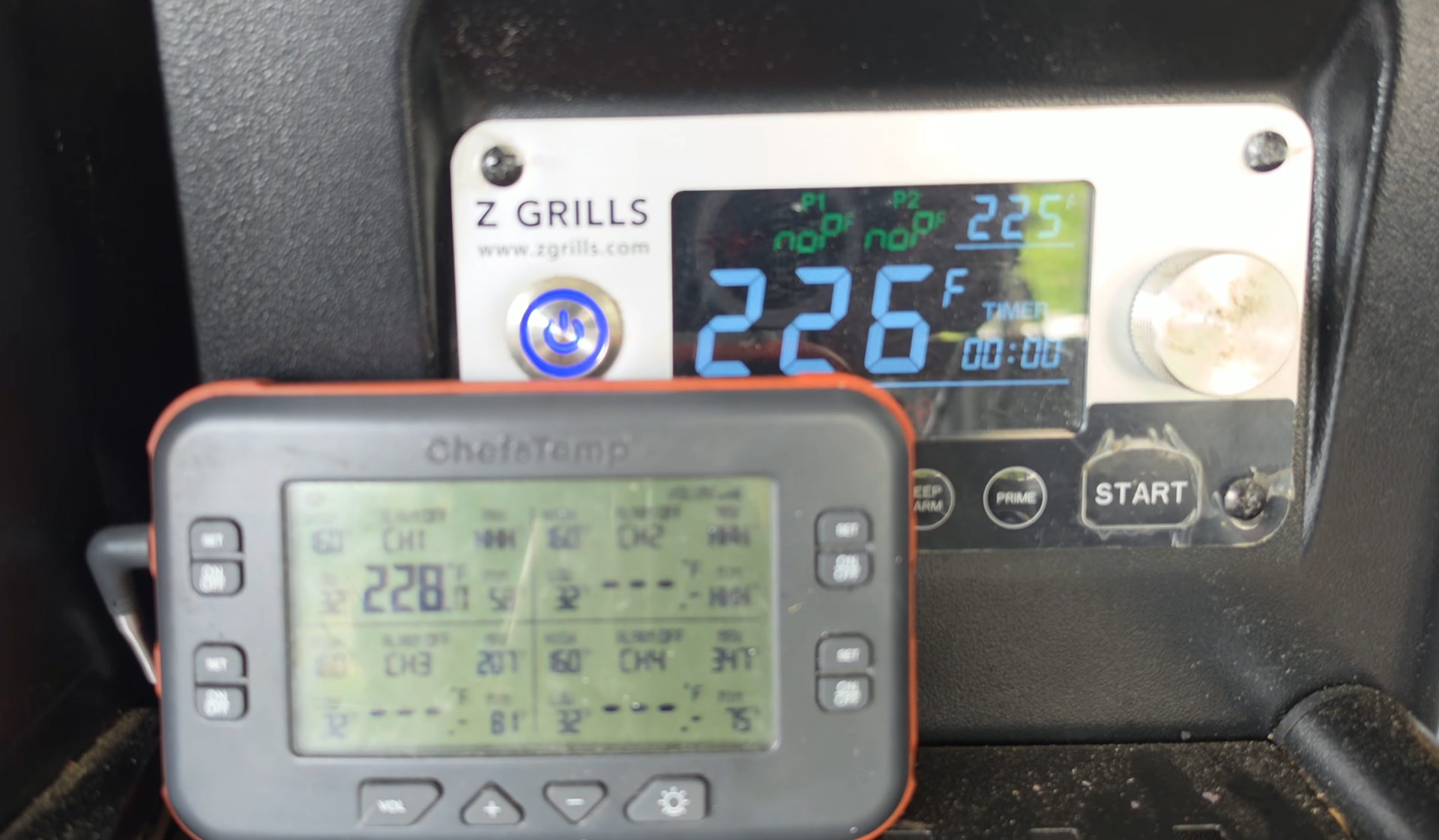 Close-up of two digital displays showing temperatures. The Z Grills display reads 226°F, while the ChefTemp device shows 228°F. Both are used for monitoring cooking or grilling. Silver buttons are visible on the Z Grills panel.