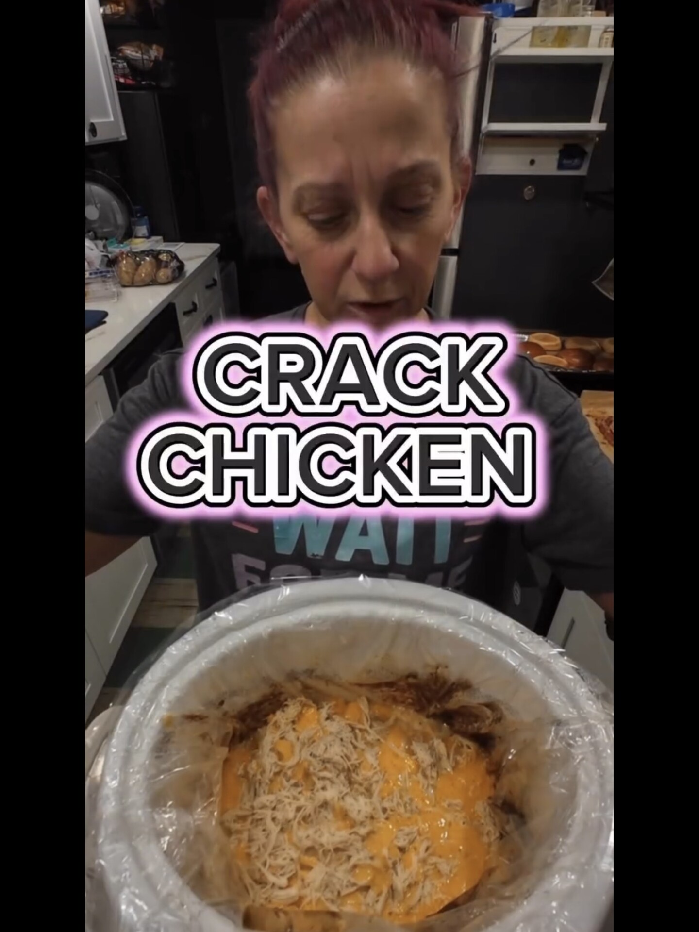 A woman looks into a slow cooker containing shredded chicken and melted cheese, with the text CRACK CHICKEN overlaid on the image.