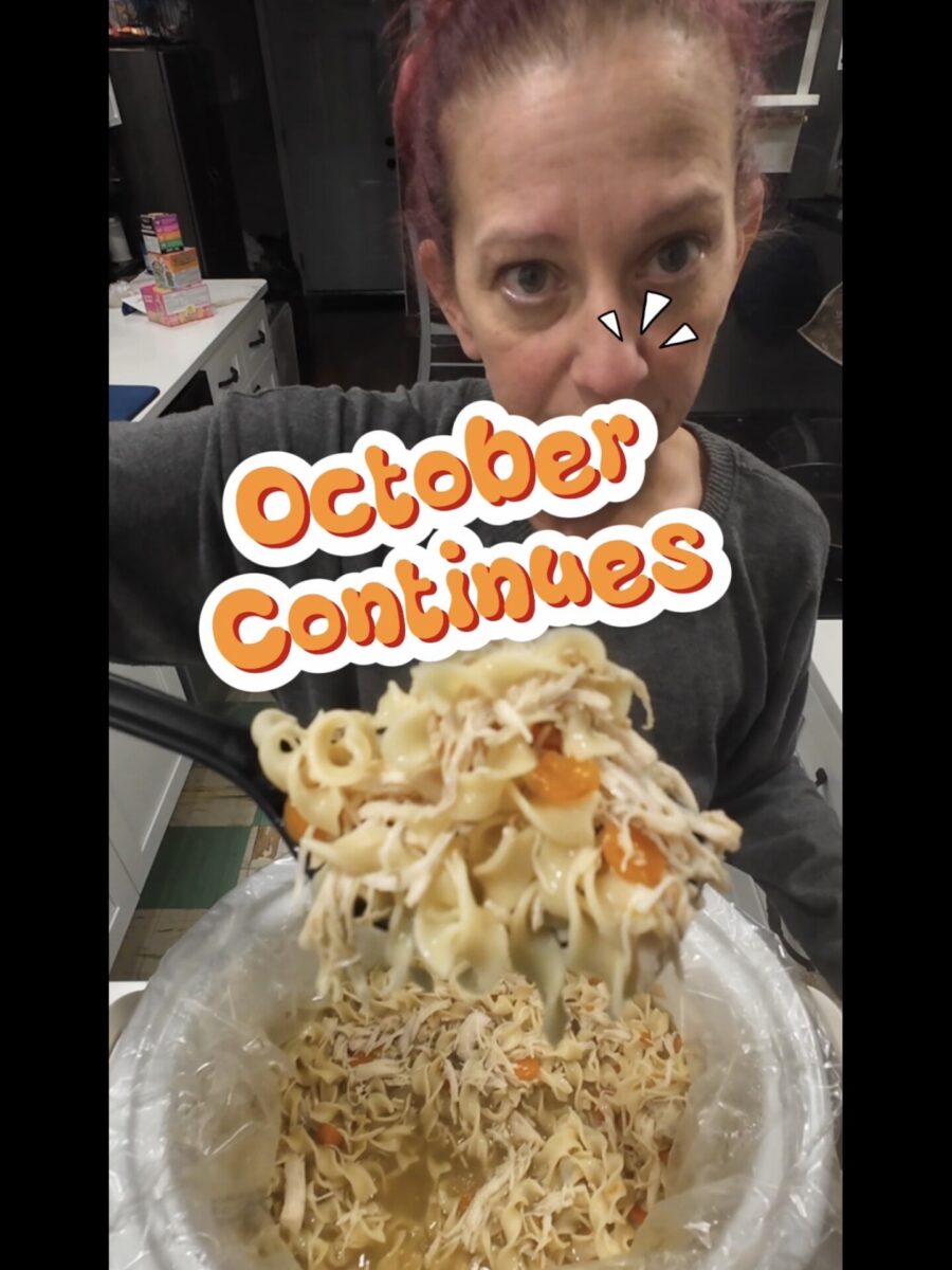 A woman holds a serving spoon filled with chicken noodle soup over a slow cooker, with the text October Continues overlaid on the image.